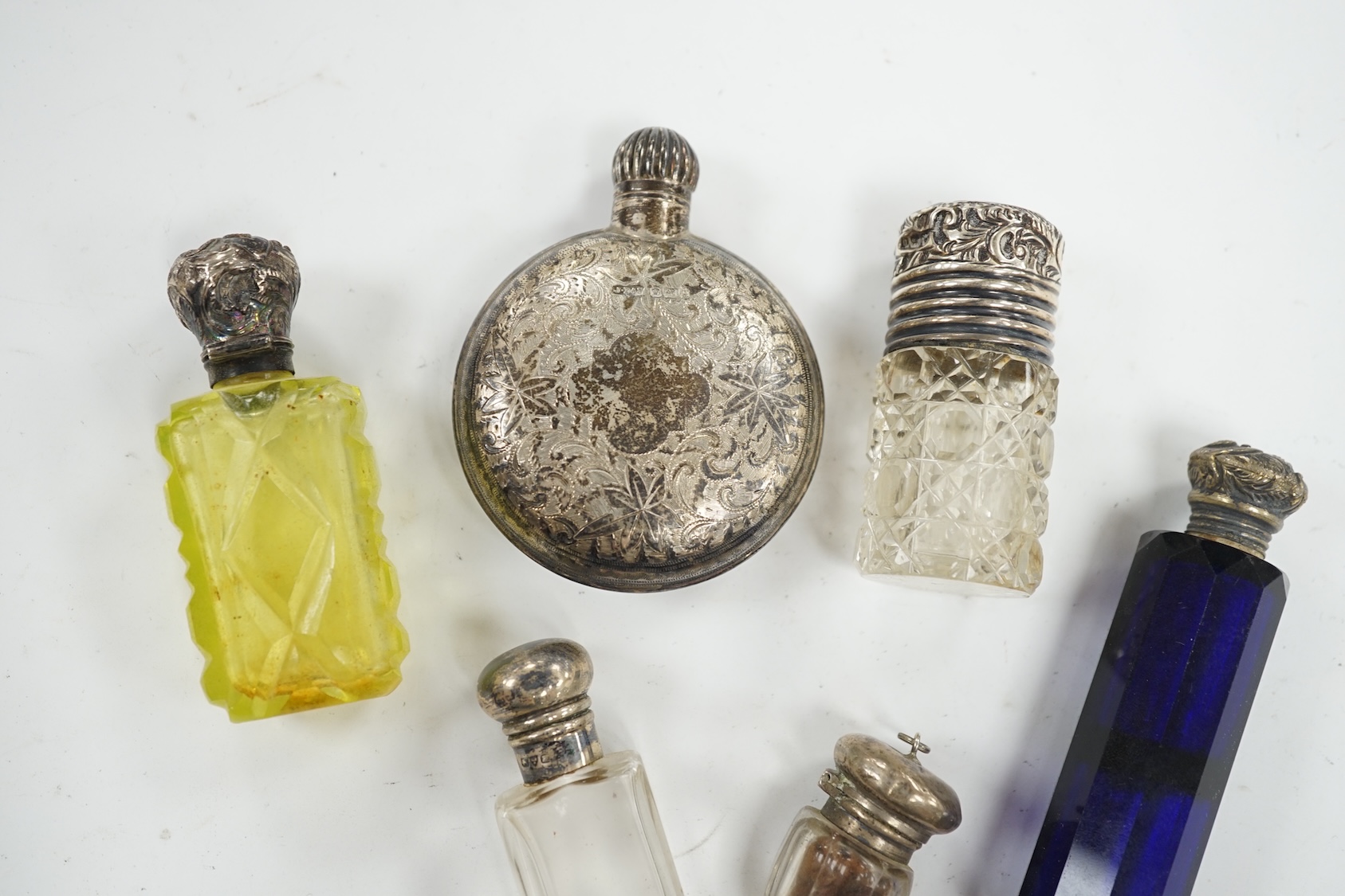 A George V engraved silver moon shaped scent bottle, James Dixon & Sons, Sheffield, 1912, together with five other white metal mounted glass scent bottles. Condition - poor to fair